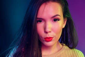 Portrait of a young mixed raced girl with braids against dark blue background