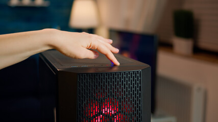 Professional esports gamer operating pc system, pressing on start button of computer unit. Woman...