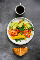 breakfast, avocado salad basil tomato and paprika, coffee with croissant. View from above