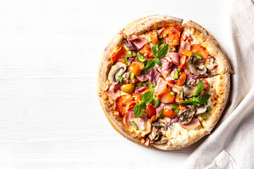 Delicious italian pizza with bacon, mushrooms, cherry tomatoes lies on a white wooden background, horizontal orientation, flat lay