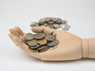 Wooden hand holding with assortment Thai coins on white background, Selective focus image.