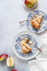 Slices of apple tart on blue plates, shot from above.