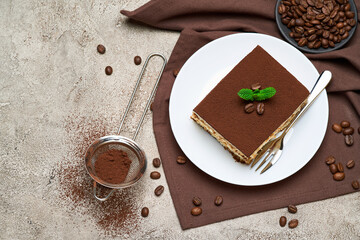 Portion of Traditional Italian Tiramisu dessert and coffee beans on grey concrete background