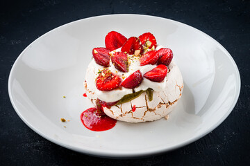Homemade meringue dessert Pavlova cake with fresh strawberries. Summer dessert. French cake. Confectionery. Classic dessert. Strawberry dessert