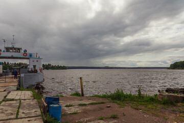 Ferry at the pier. The ship is at the pier. Crossing the Kama river. Clouds over the river.