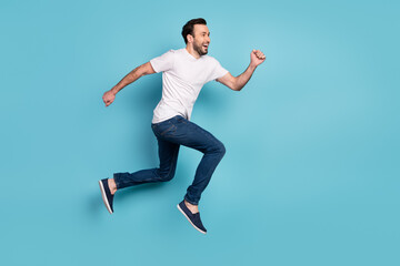Fototapeta na wymiar Full body profile portrait of excited cheerful man look empty space running isolated on blue color background