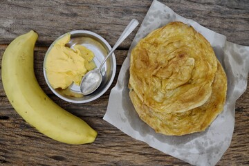 Indian naan bread homemade with butter and banana fruit on paper background India food