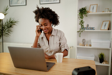 Obraz premium Cheerful African American girl is having phone call during her lunch break.