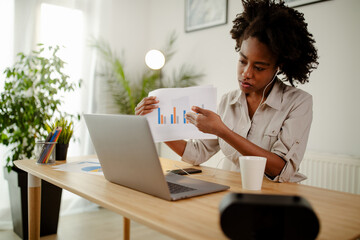Serious young businesswoman is having online conference call,showing some analysis.