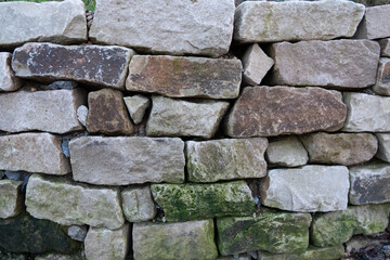 geschichtete Mauer mit groben, grauen Felsen / Steinen