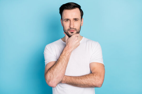 Portrait of young man hand on chin look interested camera thinking isolated on blue color background