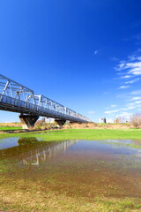 春の雨上りの江戸川河川敷と武蔵野線鉄橋風景