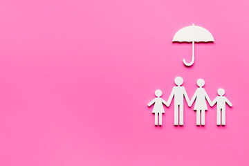 Wooden family figure under umbrella with space for text. Insurance concept