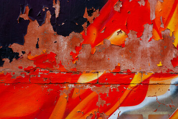 Peeling black, red and orange paint on stone or metal wall, abstract weathered texture grunge background