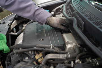 Mechanic man hand checking car engine oil