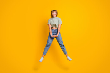 Fototapeta na wymiar Full length body size view of charming cute modest cheerful girl jumping having fun isolated over bright yellow color background