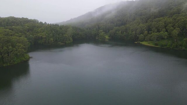 Tranquil Lake And Green Forest With Fog In Karangi Dam. Popular Destination In Coffs Harbour, Australia. aerial drone
