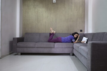 girl reading a book on the couch