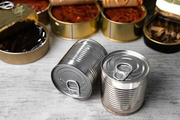 Many cans with conserved fish on wooden table