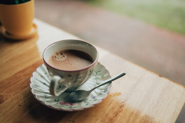 Hot coffee americano on the table. A cup of coffee in  plate.