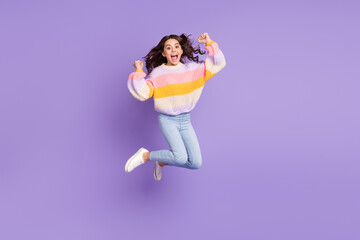 Full size photo of young happy excited crazy smiling girl jumping raise fists in victory isolated on purple color background
