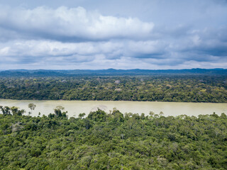 Fototapeta na wymiar Beautiful drone aerial view of Amazon rainforest trees landscape and Jamanxim river on cloudy day in Para, Brazil. Concept of nature, ecology, environment, global warming, conservation, forest.