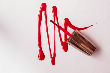 Liquid nail polish poured out onto a white backdrop