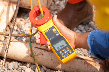 Action of electrician using ohm meter to measure electric earthing ground resistance. Industrial...