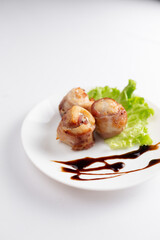 Meat rolls with bacon on white background