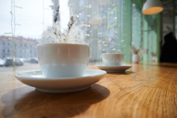 Mugs with coffee on a wooden table with blurred background