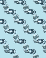 Pattern from glasses with water on a blue background. Ecological concept, space for text.