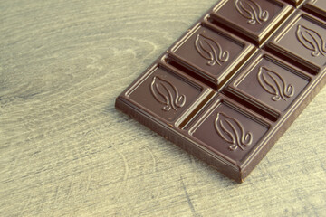 bar of dark chocolate on wood background