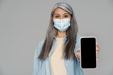Mature white-haired woman in face mask pandemic mobile phone