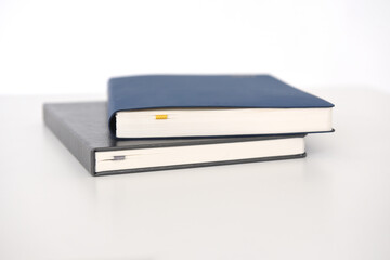 two paper notebooks with a cover on a white background