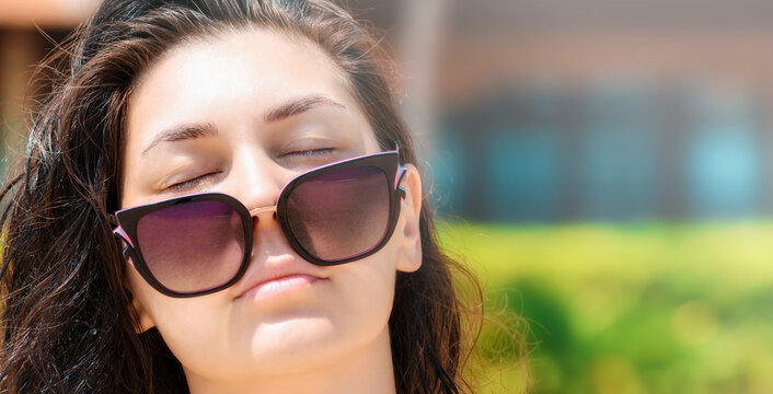 Beautiful girl with closed eyes in sunglasses.