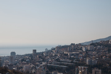 panorama of a small town at dawn, mountains, sea and haze with fog