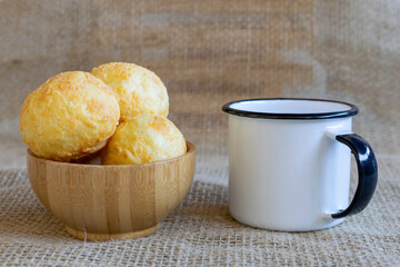 wooden bowl with cheese bread and white coffee mug