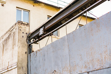 Rusty automatic metallic gate. Entrance system checkpoint. Tall iron grey gate. Gray. Security....