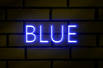 Obraz premium Neon sign - BLUE on a yellow brick wall
