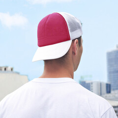Young man in a black and white trucker hat and white t-shirt. Trucker hat mock up. Baseball cap...
