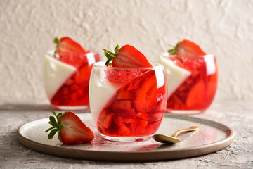 Two-color jelly of strawberries and cream in a beautiful glass, in a spring composition.