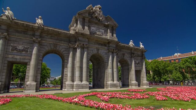The Puerta de Alcala timelapse hyperlapse (Alcala Gate) with flowers and traffic is a Neo-classical monument in the Plaza de la Independencia (Independence Square) in Madrid, Spain.
