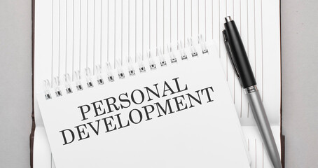 Words personal development text on notepad and pen