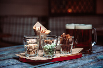 snacks to beer in glass glasses on a wooden table