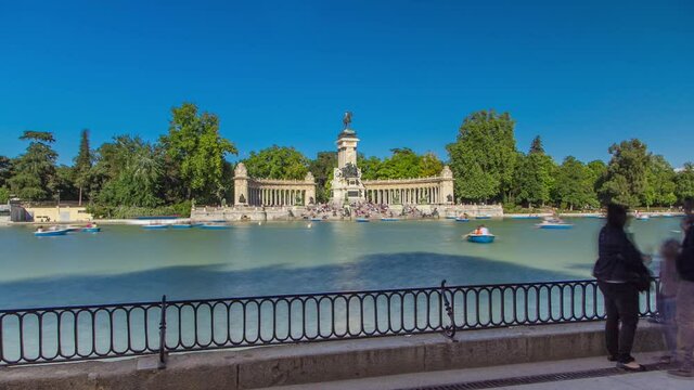 Tourists on boats at Monument to Alfonso XII timelapse hyperlapse in the Parque del Buen Retiro - Park of the Pleasant Retreat in Madrid, Spain