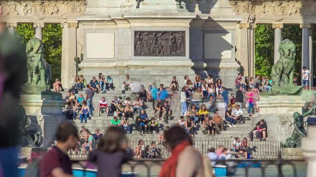 Tourists on boats and people sitting at Monument to Alfonso XII timelapse in the Parque del Buen Retiro - Park of the Pleasant Retreat in Madrid, Spain