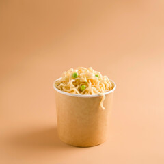 Food delivery concept. Noodles in a paper cup. Copy space