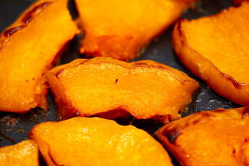 Pieces of pumpkin baked on a baking sheet. Food