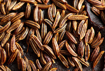 Cumin seeds on rye bread as background.