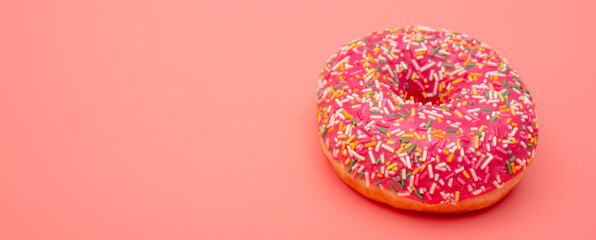 Red donut on a pink background.